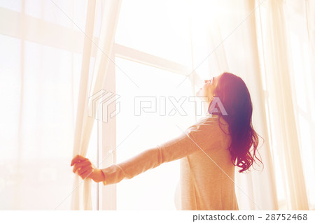 close up of pregnant woman opening window curtains 28752468