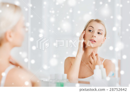 happy young woman looking to mirror at bathroom 28752642