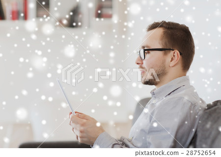 man with tablet pc at home over snow 28752654