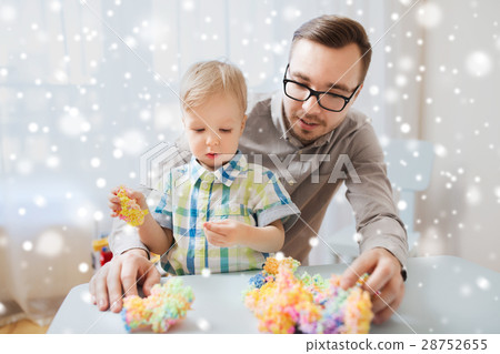 father and son playing with ball clay at home 28752655