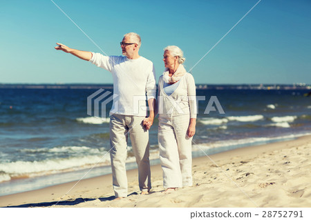 happy senior couple walking on summer beach happy senior couple walking on summer beach 28752791