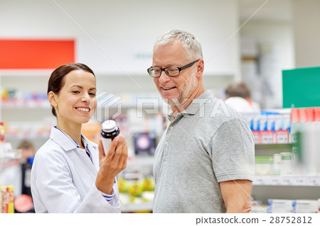 pharmacist showing drug to senior man at pharmacy pharmacist showing drug to senior man at pharmacy 28752812