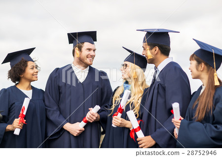 happy students in mortar boards with diplomas 28752946