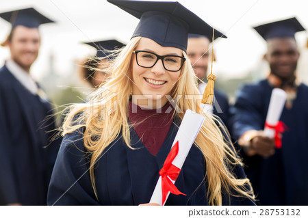 happy students in mortar boards with diplomas 28753132