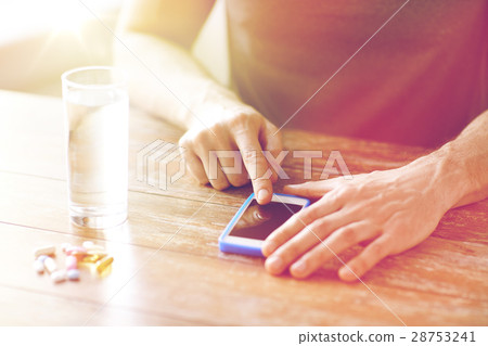 close up of hands with smartphone, pills and water close up of hands with smartphone, pills and water 28753241
