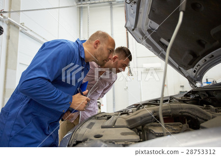 auto mechanic with clipboard and man at car shop 28753312