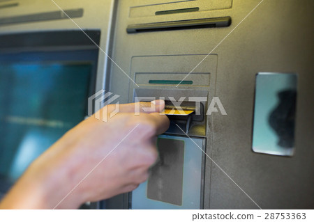 close up of hand inserting card to atm machine close up of hand inserting card to atm machine 28753363