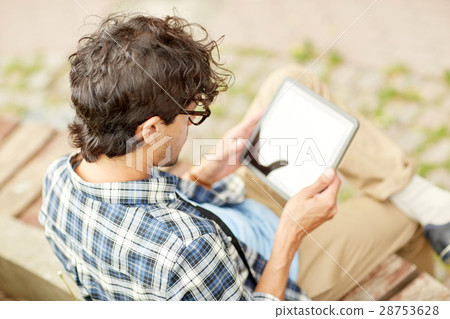 man with tablet pc sitting on city street bench 28753628