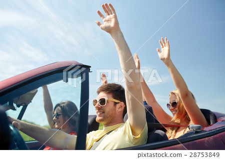 happy friends driving in cabriolet car at country 28753849
