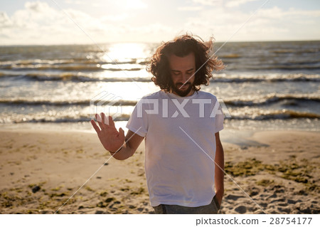 happy man in white t-shirt on beach over sea happy man in white t-shirt on beach over sea 28754177