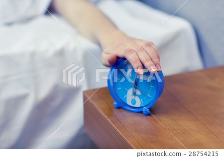 close up of hand on alarm clock in bedroom 28754215