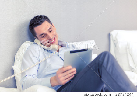 businessman with tablet pc and phone in hotel room businessman with tablet pc and phone in hotel room 28754244