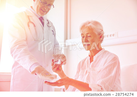 doctor giving medicine to senior woman at hospital 28754274