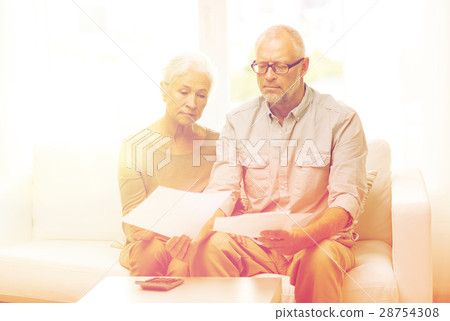 senior couple with papers and calculator at home 28754308
