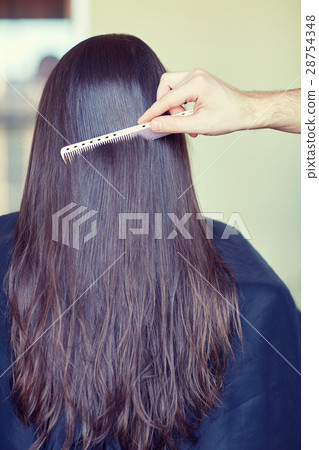 hand with comb combing woman hair at salon hand with comb combing woman hair at salon 28754348