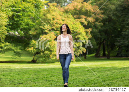 beautiful happy young woman walking in summer park beautiful happy young woman walking in summer park 28754417