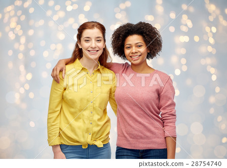 happy smiling women hugging over holidays lights happy smiling women hugging over holidays lights 28754740