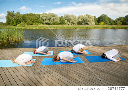 group of people making yoga exercises outdoors 28754777