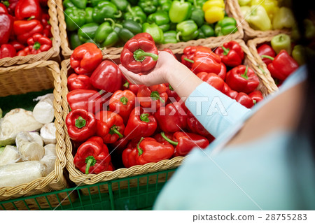 woman with basket buying peppers at grocery store 28755283