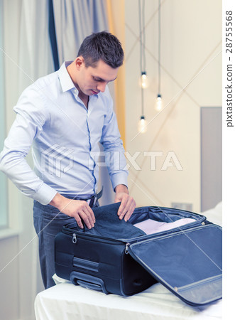 businessman packing things in suitcase businessman packing things in suitcase 28755568