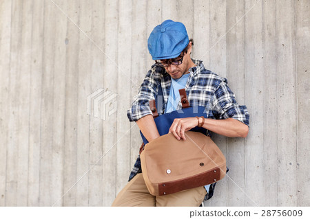 hipster man looking for something in his bag hipster man looking for something in his bag 28756009