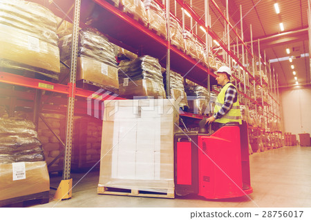 man on forklift loading cargo at warehouse 28756017