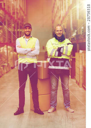 men in uniform with boxes at warehouse 28756318