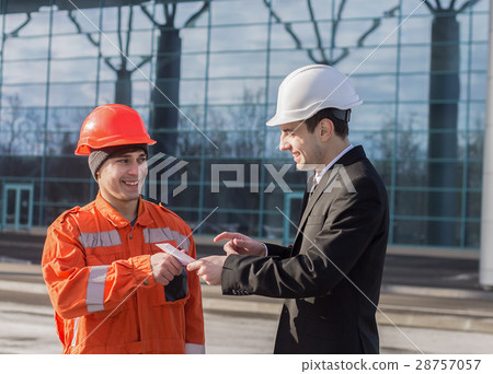 boss giving salary in an envelope and smiling 28757057