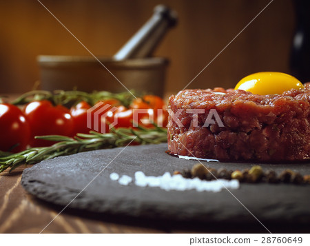 Beef tartar with an egg on a stone plate. Beef tartar with an egg on a stone plate. 28760649