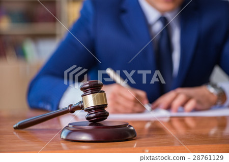 Handsome judge with gavel sitting in courtroom 28761129