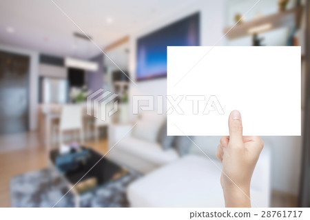 hand holding blank paper with interior background hand holding blank paper with interior background 28761717