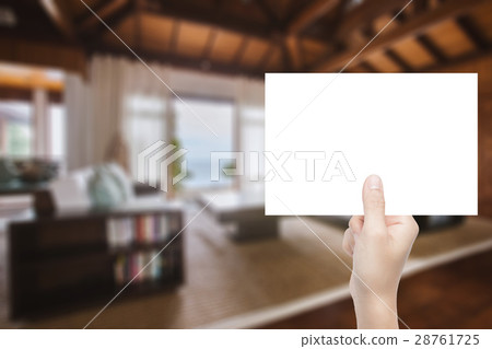 hand holding blank paper with interior background hand holding blank paper with interior background 28761725