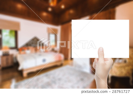 hand holding blank paper with interior background hand holding blank paper with interior background 28761727