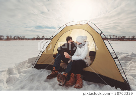 Young couple in tent hold hands at winter hike 28763359