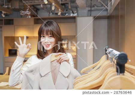 A young woman hanging a stylish clothes 28763646