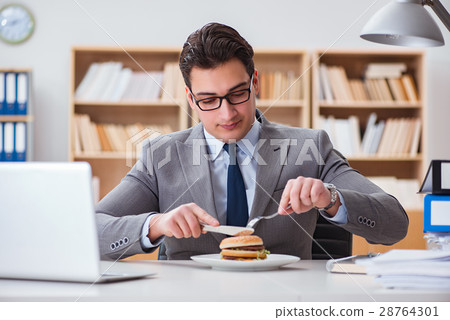 Hungry funny businessman eating junk food sandwich Hungry funny businessman eating junk food sandwich 28764301