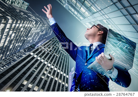 Businessman with laptop against the building 28764767