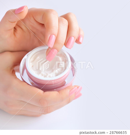 Hands of a woman with pink manicure with cream 28766635