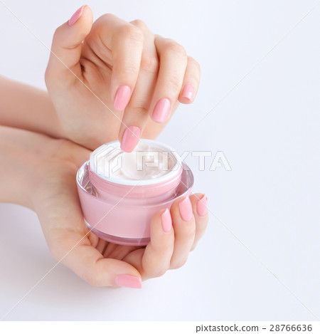 Hands of a woman with pink manicure with cream 28766636