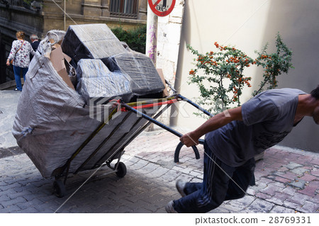 Porter drags a cart with boxes in Istanbul 28769331