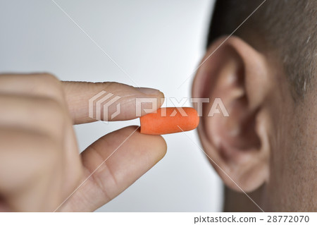 man putting on an earplug 28772070