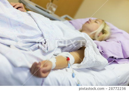 Bedridden female patient recovering after surgery 28772236