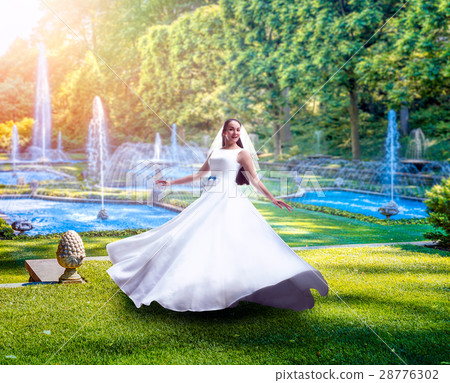 Young bride in green park with fountains Young bride in green park with fountains 28776302