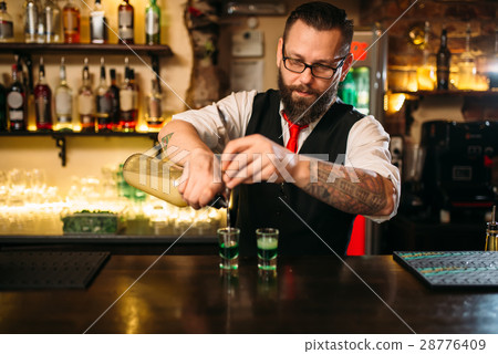 Barkeeper pouring alcoholic beverage in glass Barkeeper pouring alcoholic beverage in glass 28776409