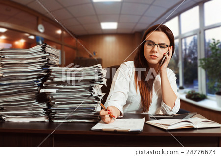 Woman bookkeeper using mobile phone at workplace Woman bookkeeper using mobile phone at workplace 28776673