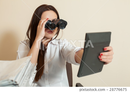 Bookkeeper looks through binoculars on calculator Bookkeeper looks through binoculars on calculator 28776675