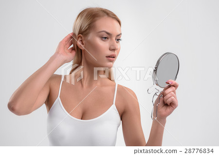 Voluptuous blond girl looking at her appearance 28776834
