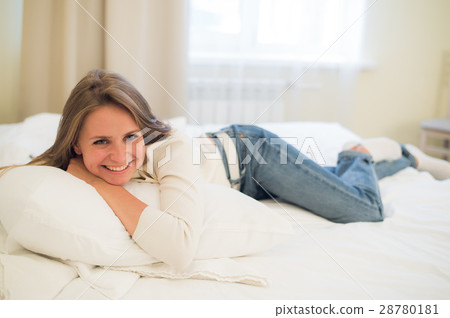 Smiling thoughtful pretty woman lying in bed at Smiling thoughtful pretty woman lying in bed at 28780181