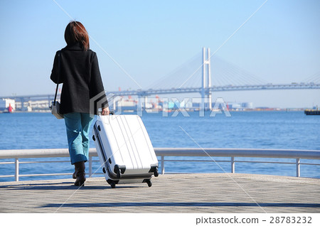 Women travelers with white suitcases at the port 28783232