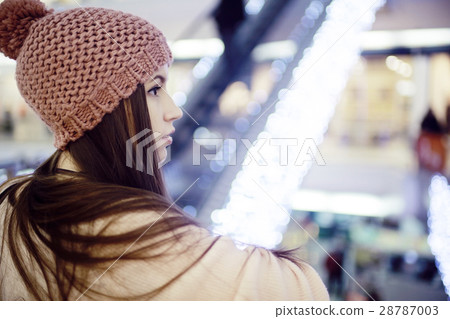 girl in a knitted hat walking in the mall 28787003